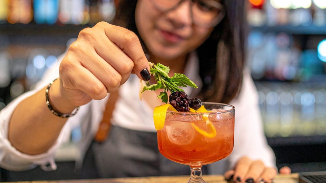 Refreshing summer drinks on a restaurant patio, including iced tea, mocktails, sparkling water, and seasonal beverages